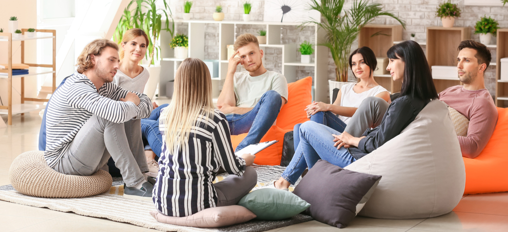 Asking for Time Off Work for Addiction Treatment Emerald Isle - A group of individuals in residential rehab are discussing their stories during an addiction treatment group therapy session as part of their recovery process.
