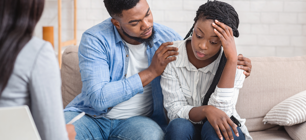 Being in a Relationship with Person Struggling with Addiction - Emerald Isle - A husband comforts his wife as they attend a therapy session focused on being in a relationship with a person struggling with addiction.