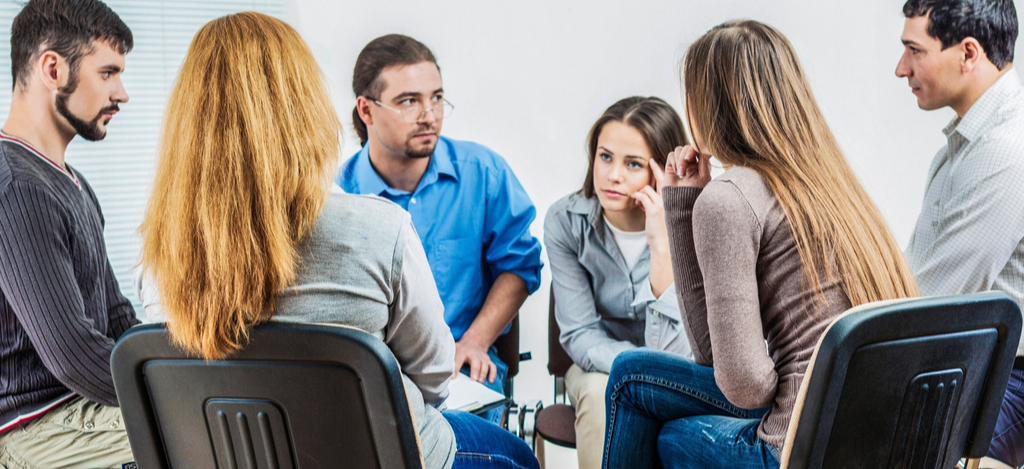 Why Are Knowing the Symptoms of Alcohol Abuse Important? Emerald Isle Health and Recovery - A group of individuals in residential treatment for alcoholism is discussing various coping strategies to help manage stress and pain without turning toward an alcoholic drink.