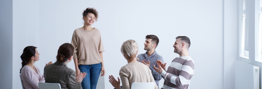 Inpatient Alcohol Rehab - A woman stands and speaks during her group therapy session. Inpatient alcohol rehab has shown the most success in the fight against alcoholism.