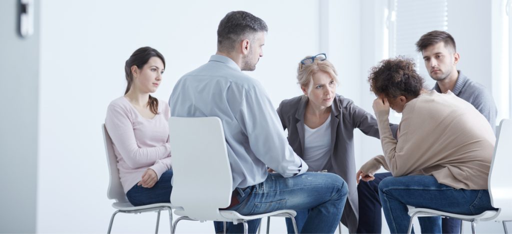 Relapse - During group therapy the therapist consoles a woman who had a relapse and is now back in addiction treatment.